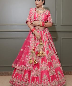Elegant Indian bride wearing a vibrant pink lehenga, adorned with intricate embroidery, showcasing cultural heritage.