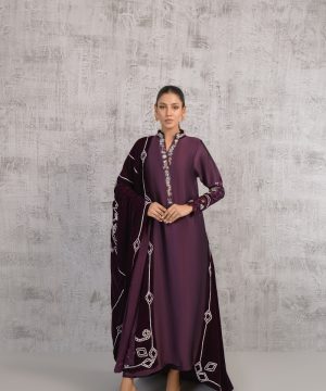 A woman in a purple dress standing in front of a wall
