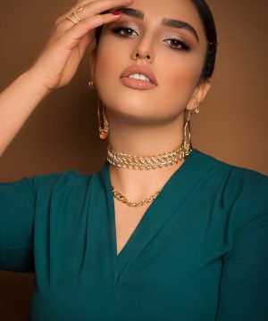 A woman in a green dress holding her hands to her face