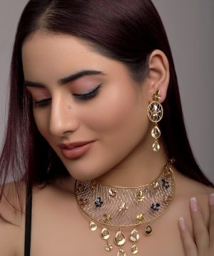 a woman wearing a gold necklace and earrings
